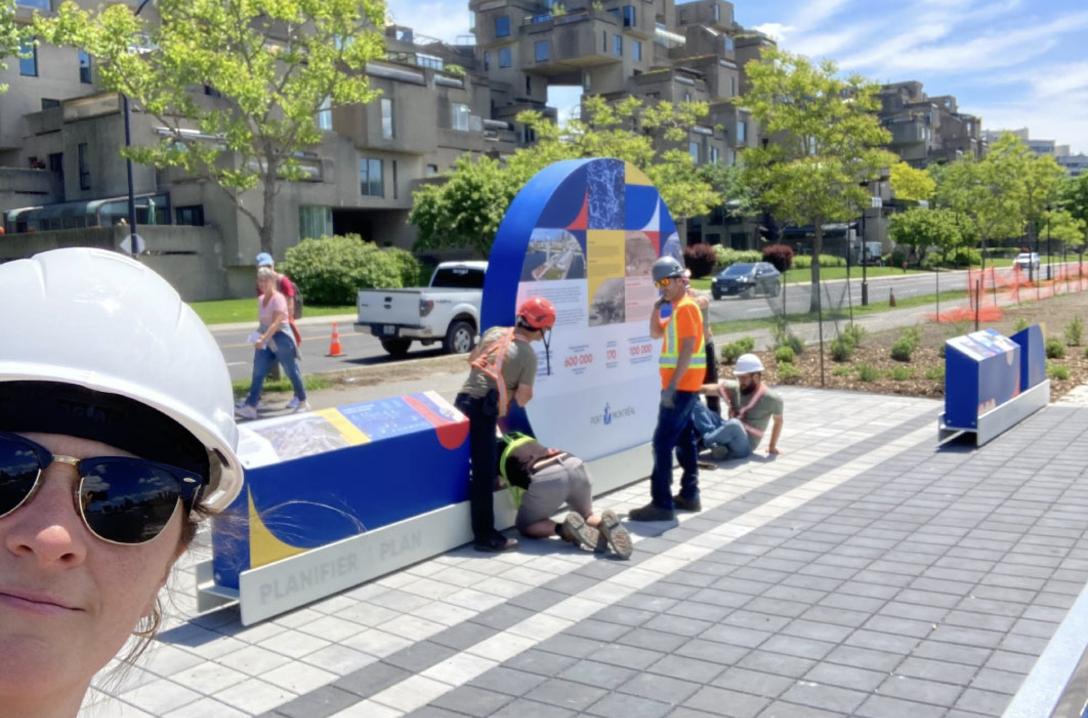 Équipe de Studio Overall installant une installation muséographique interactive en plein air.