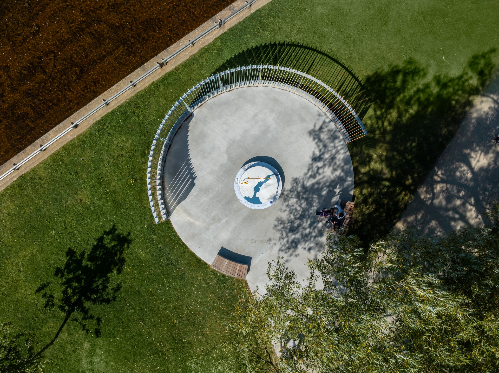 Vue aérienne d'une installation circulaire de Studio Overall, avec jardin et rivière.