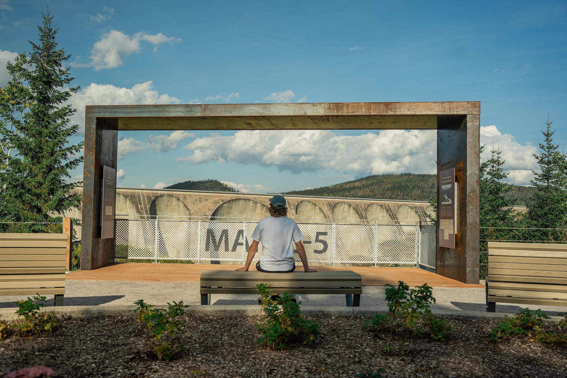 Visite guidée d'une installation muséographique avec vue sur un barrage.