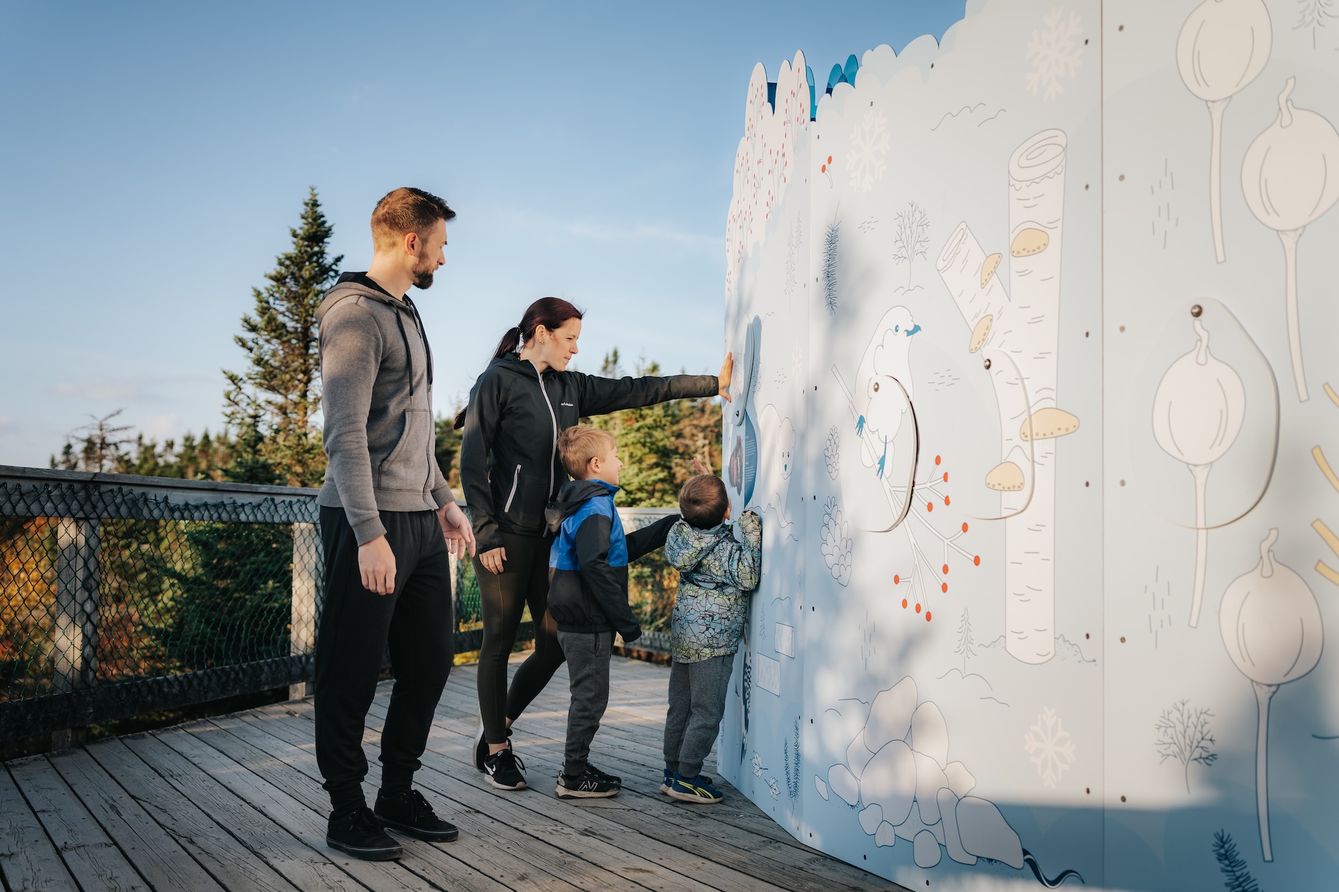Famille explorant une installation muséographique en plein air, œuvre de Studio Overall.