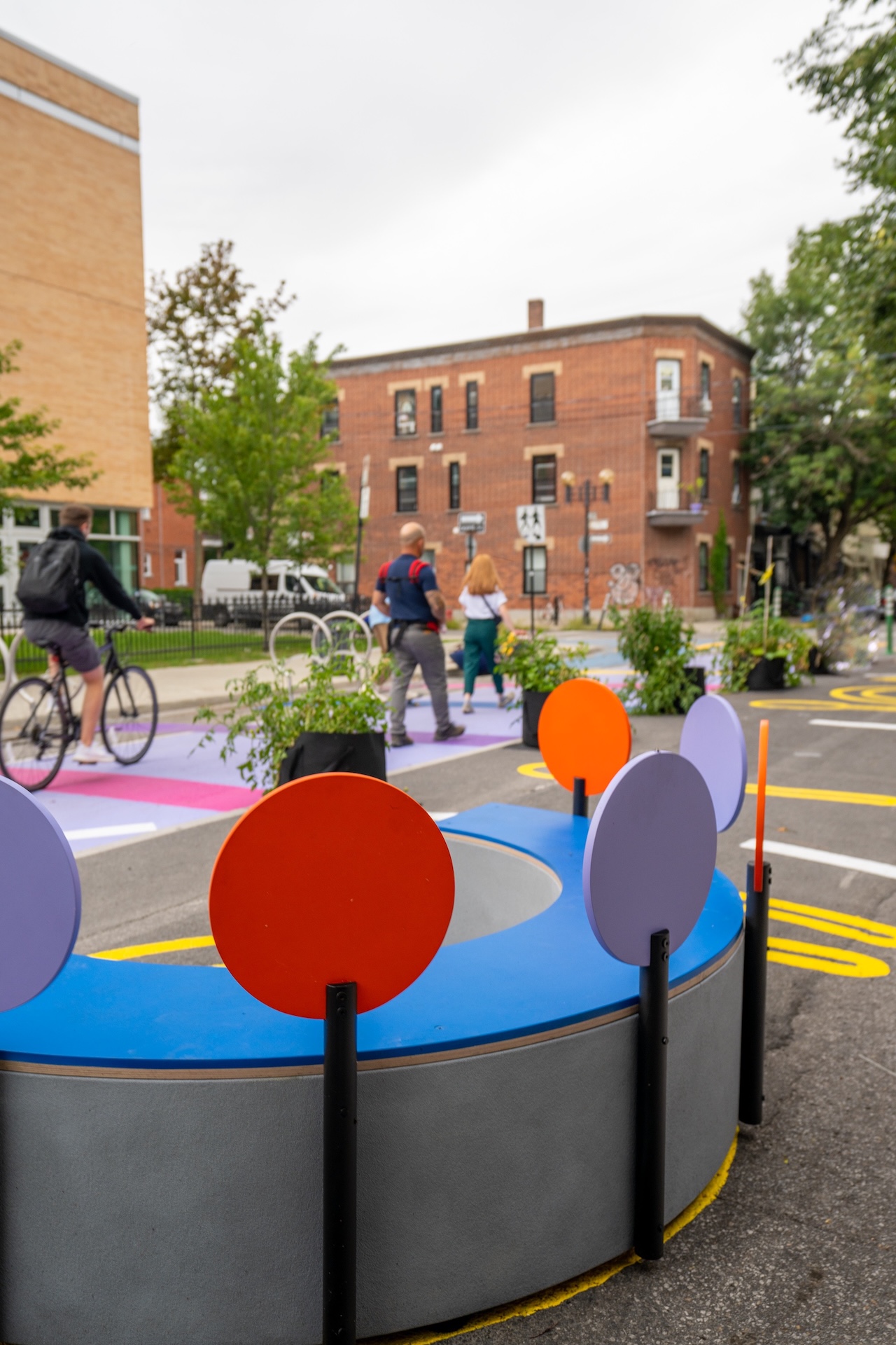 Installation urbaine colorée avec des cercles décoratifs, dans un quartier animé.