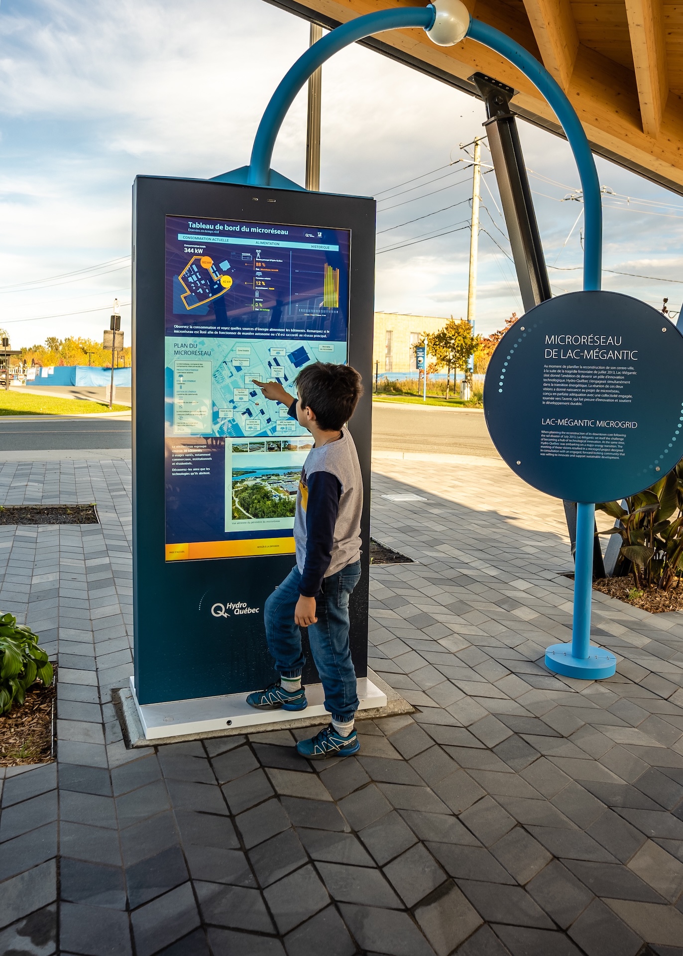 Écran interactif du micro-réseau de Lac-Mégantic, avec un enfant en train d'explorer les données énergétiques.