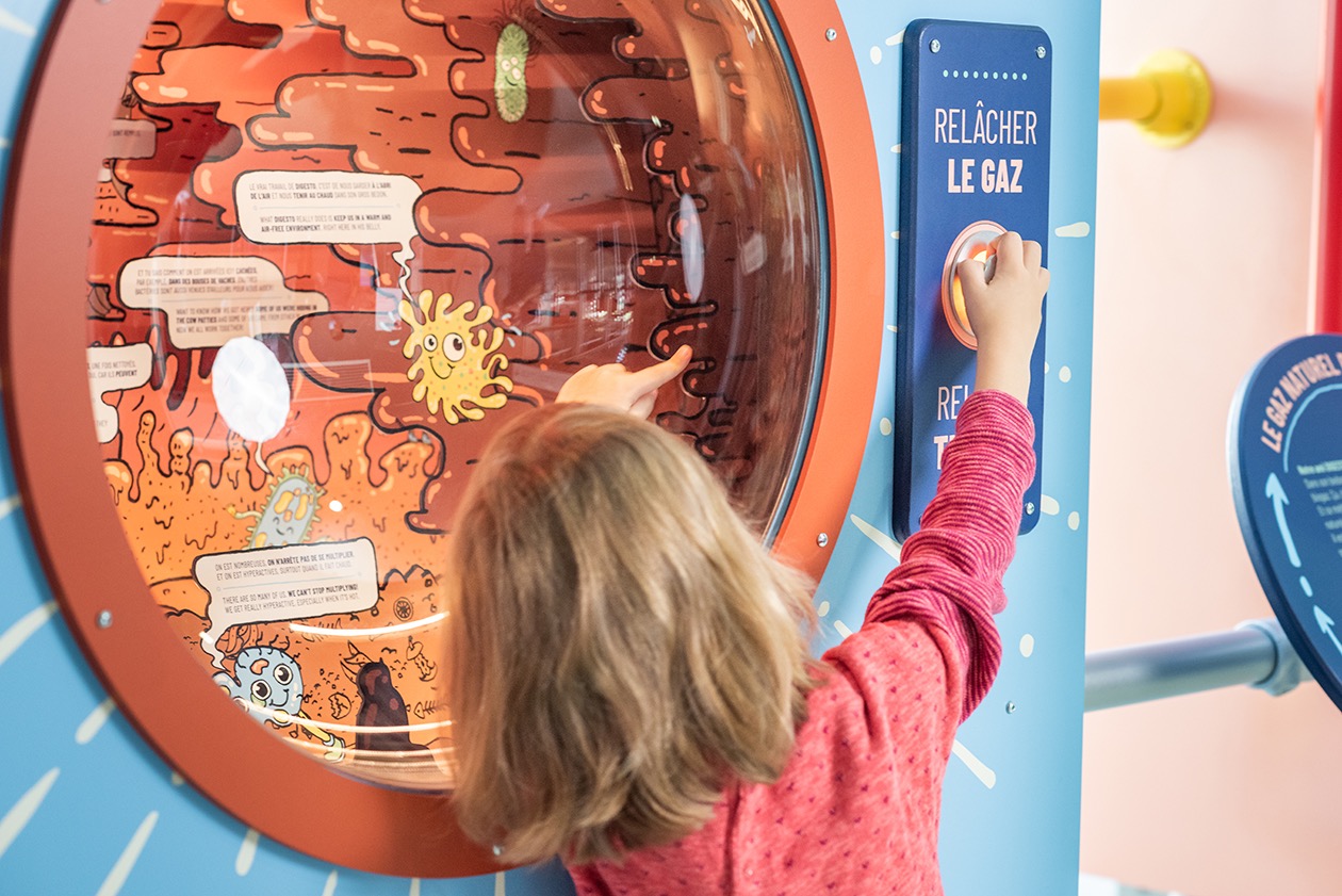 Enfant interagissant avec une installation muséographique éducative sur le gaz naturel.
