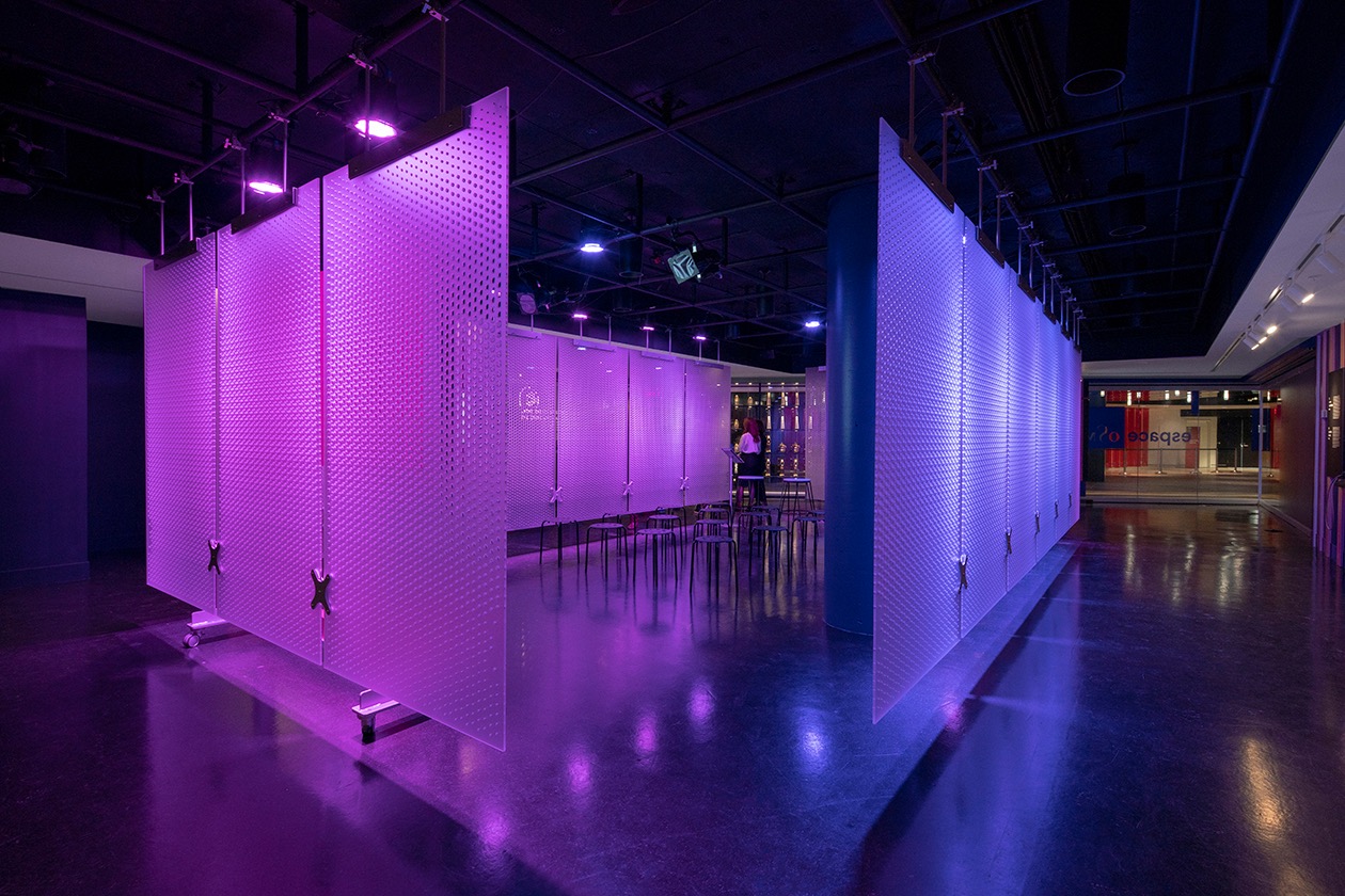 Installation lumineuse moderne avec cloisons perforées éclairées en violet, espace de création design.