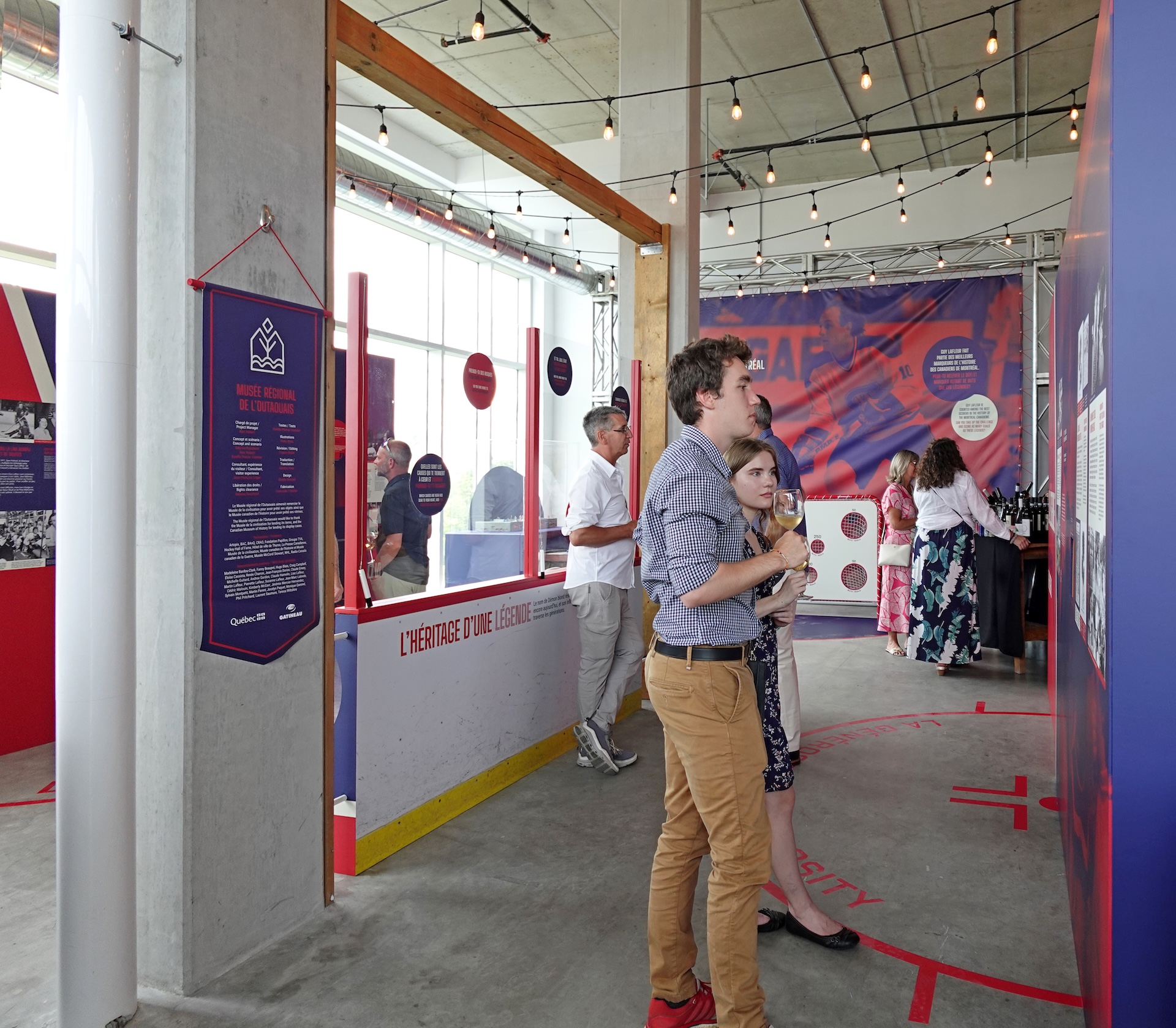 Exposition muséographique de Studio Overall, visite guidée dans un espace design avec panneaux d'information.