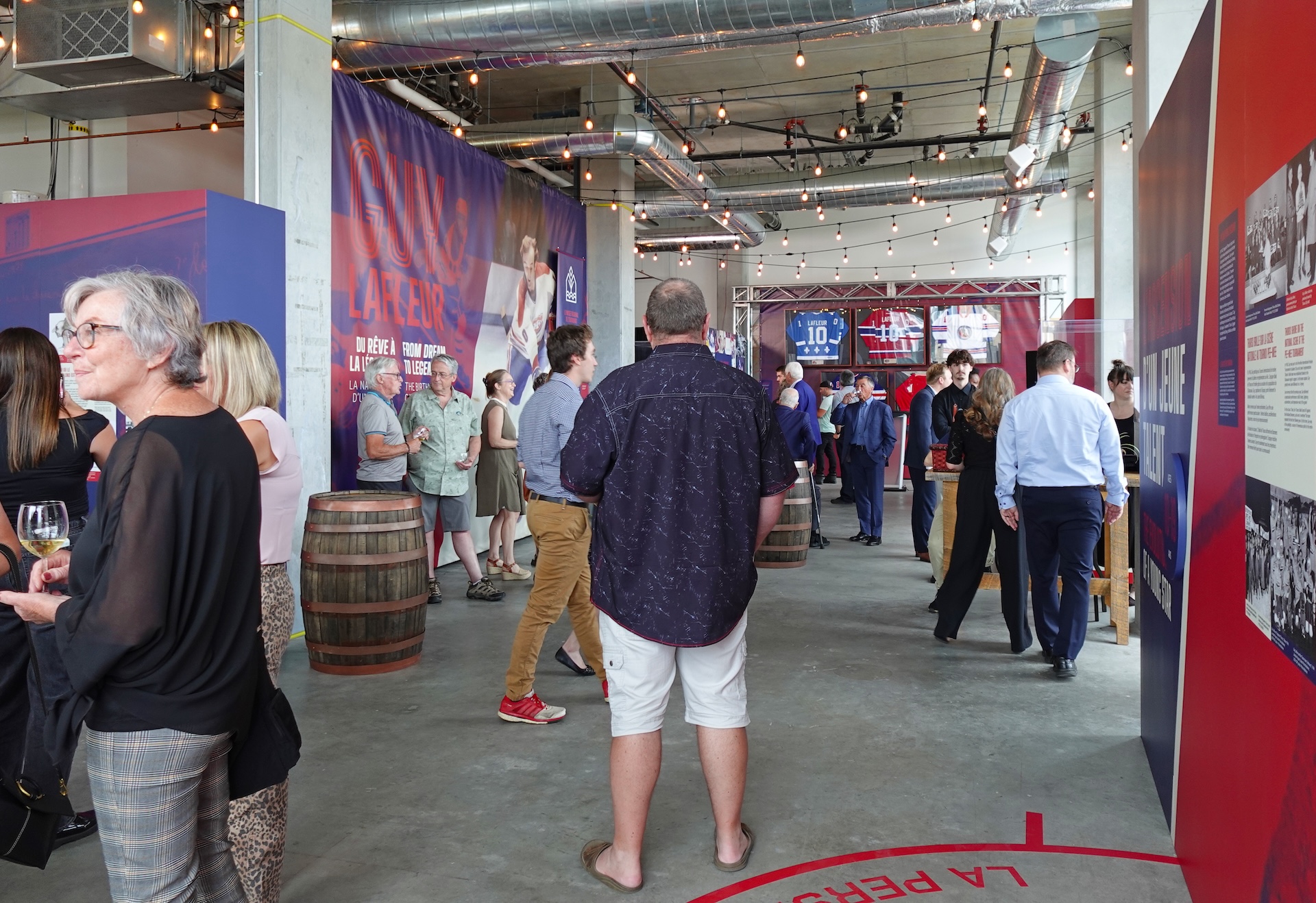 Exposition sur Guy Lafleur, avec visiteurs découvrant les installations muséales de Studio Overall.