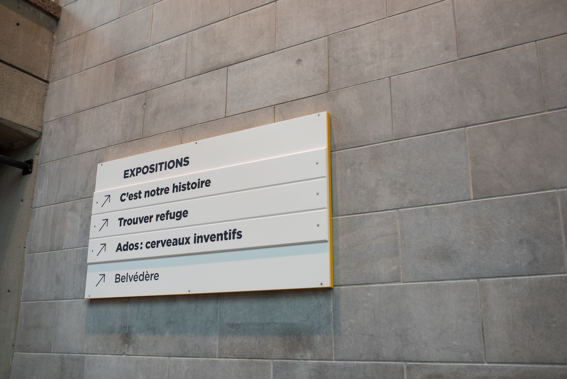 Panonceau d'exposition avec indications en français dans un espace muséal.