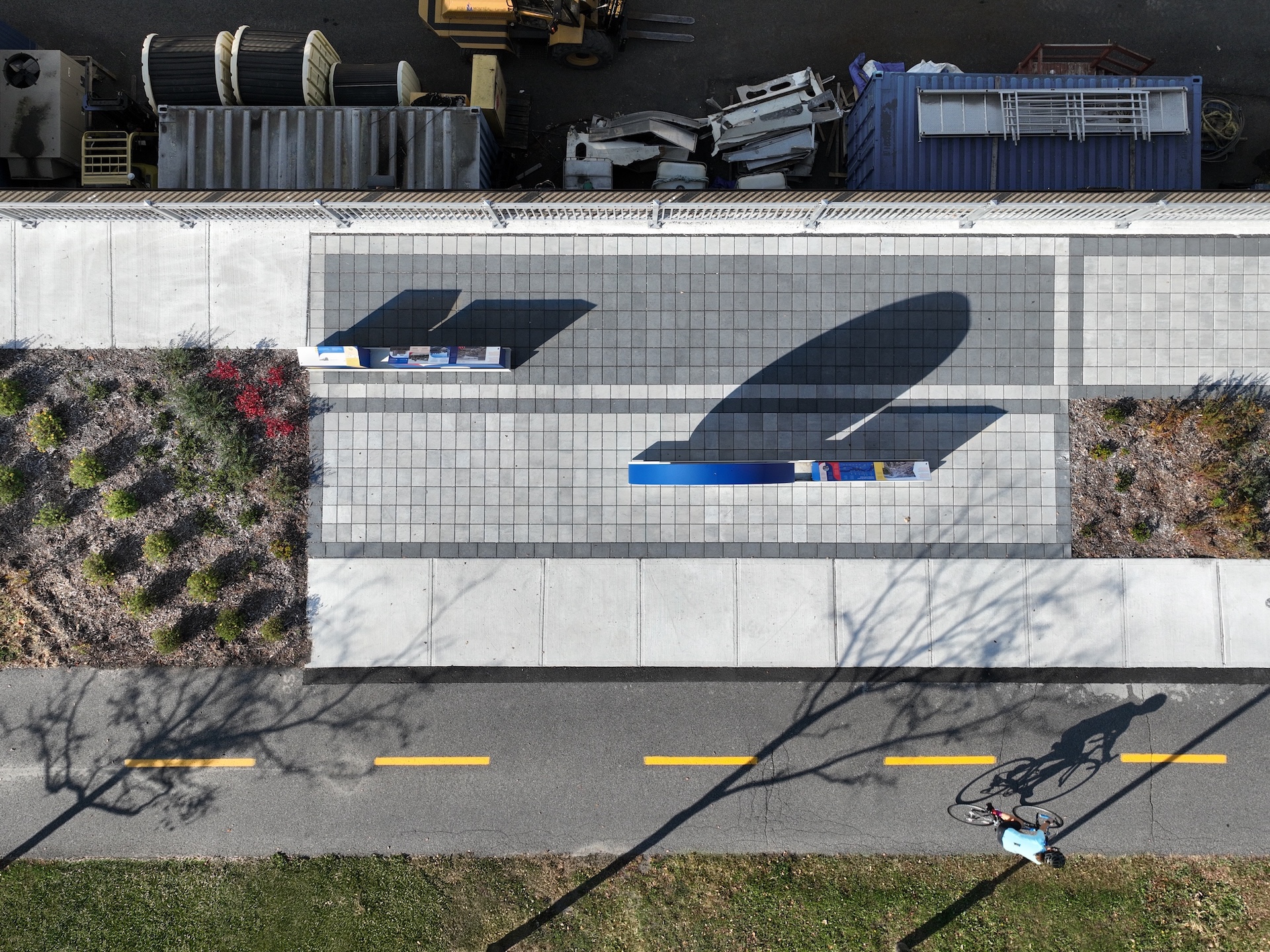 Vue aérienne d'une installation artistique en plein air avec un cycliste en arrière-plan.