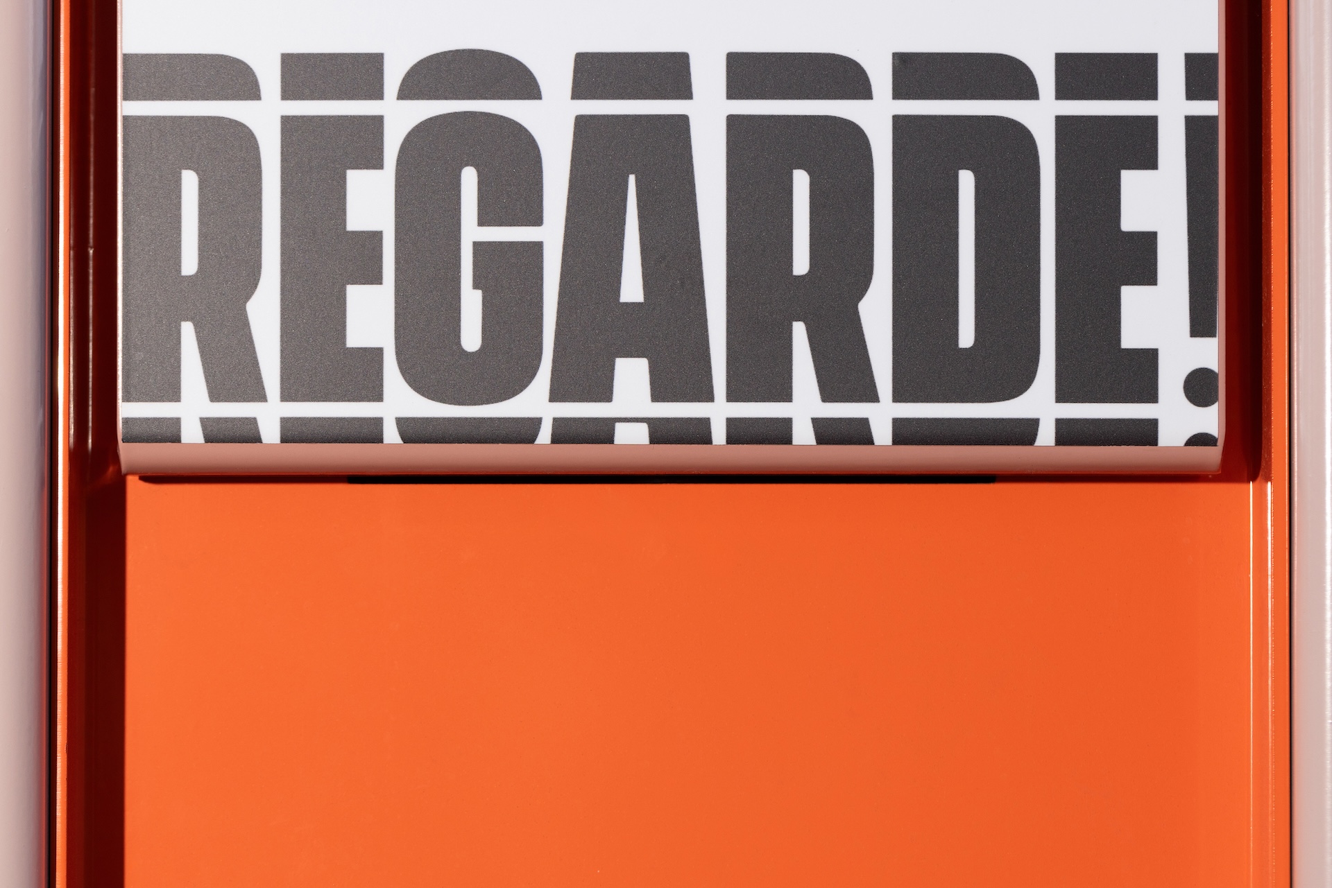 Texte en gris sur fond blanc, encadré de orange, avec l'inscription 